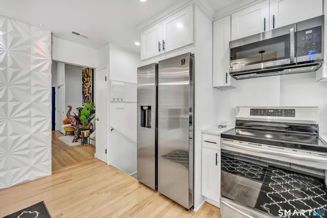 a kitchen with stainless steel appliances a refrigerator and a stove top oven