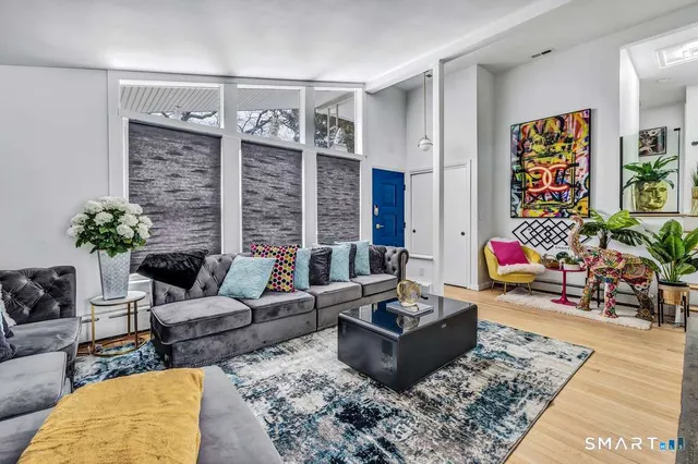a living room with furniture potted plant and a table