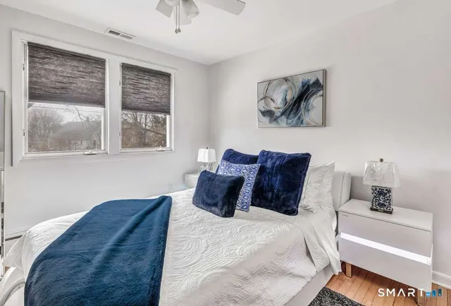 a bed sitting in a bedroom next to a window