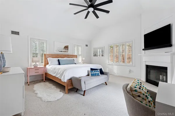 a bed room with a bed a flat screen tv and a fireplace