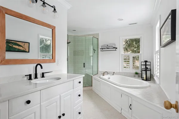 a bathroom with a tub a sink and mirror