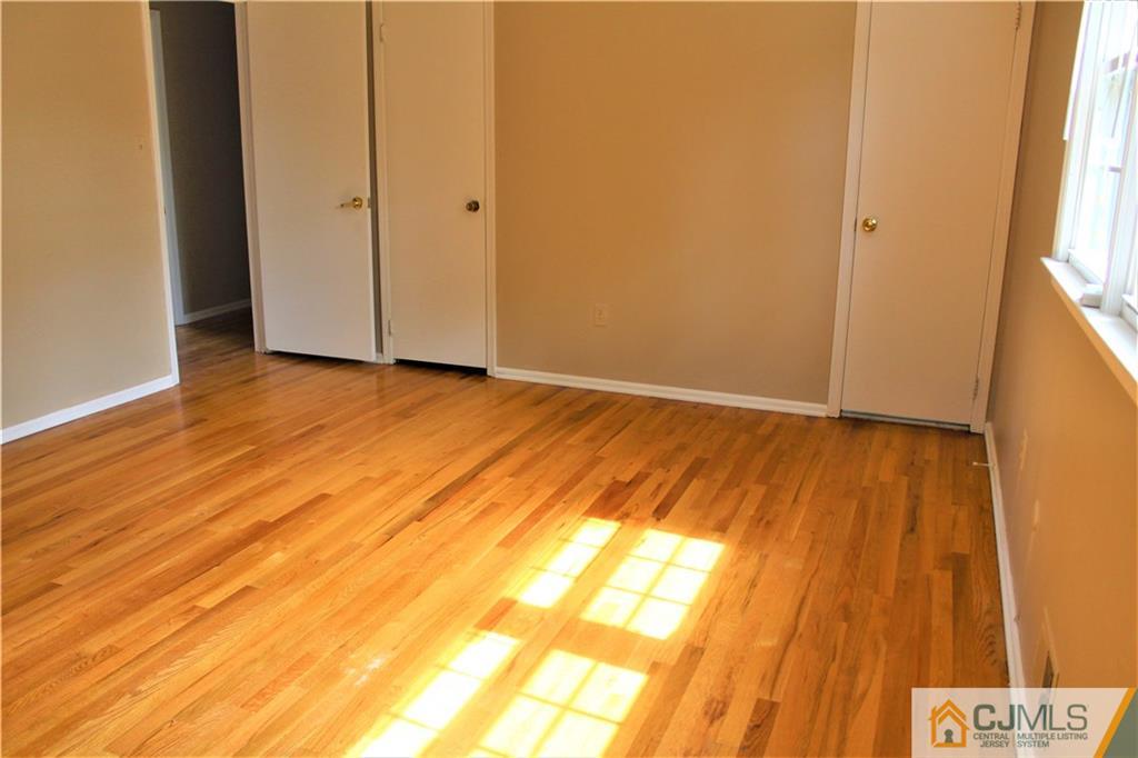 205 Normandy Road Edison, NJ 08820 - Photo 18 of 25 a view of an empty room with wooden floor and a window