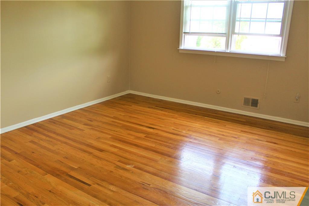 205 Normandy Road Edison, NJ 08820 - Photo 21 of 25 an empty room with wooden floor and windows