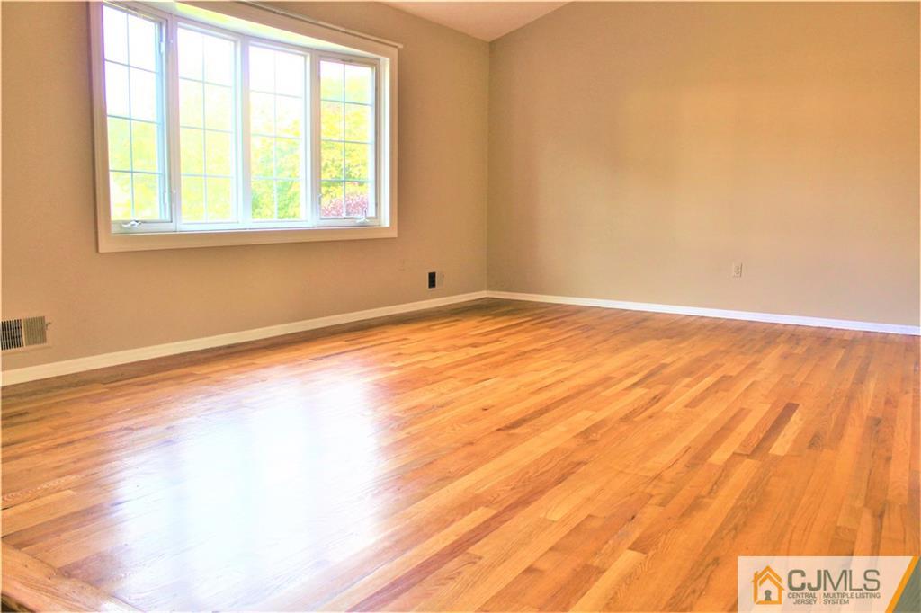 205 Normandy Road Edison, NJ 08820 - Photo 6 of 25 an empty room with wooden floor and windows