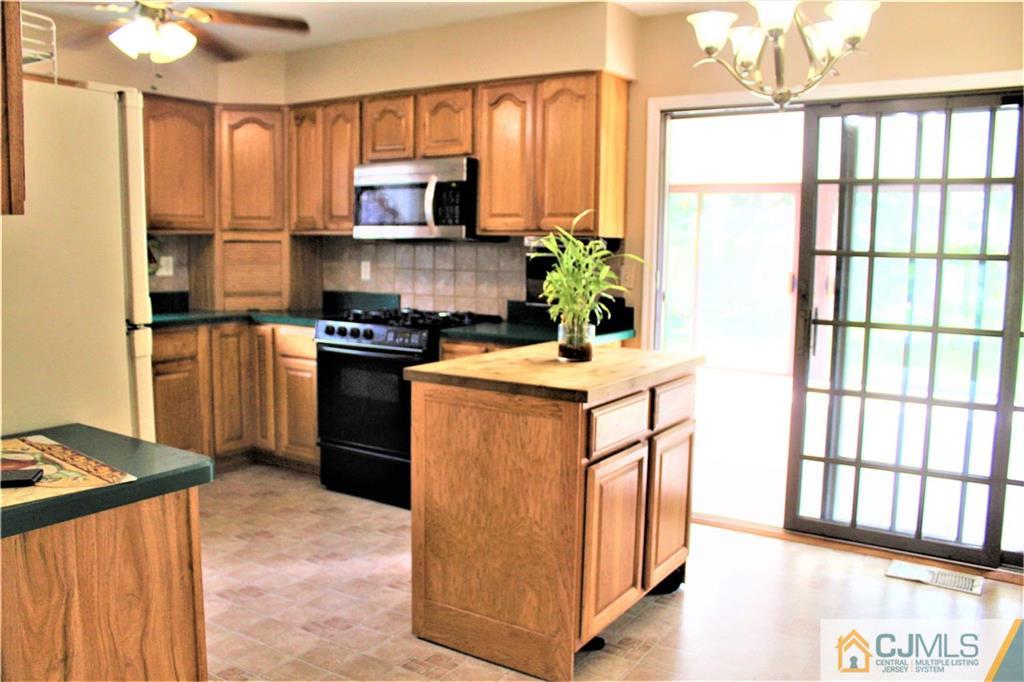 205 Normandy Road Edison, NJ 08820 - Photo 7 of 25 a kitchen with stainless steel appliances granite countertop a stove top oven a sink a refrigerator and a microwave