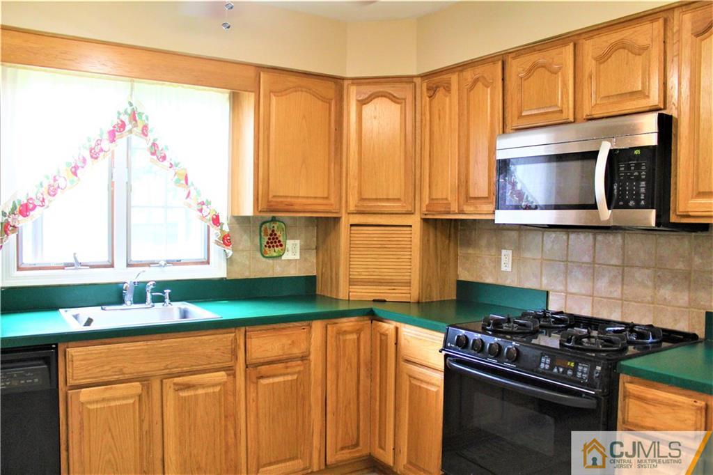 205 Normandy Road Edison, NJ 08820 - Photo 9 of 25 a kitchen with stainless steel appliances granite countertop a stove a sink and a microwave