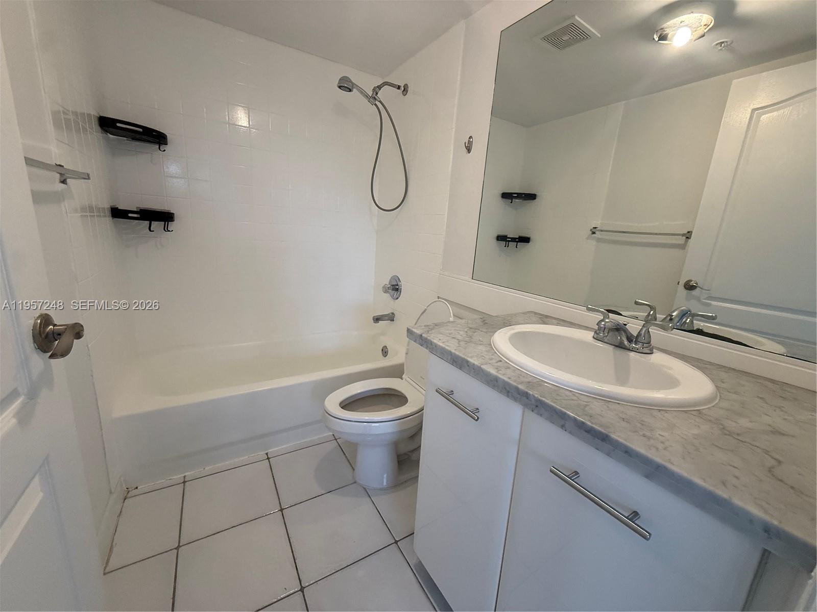 3052 Southwest 27th Avenue, Unit 301 Miami, FL 33133 - Photo 14 of 16 a bathroom with a granite countertop sink a toilet and shower