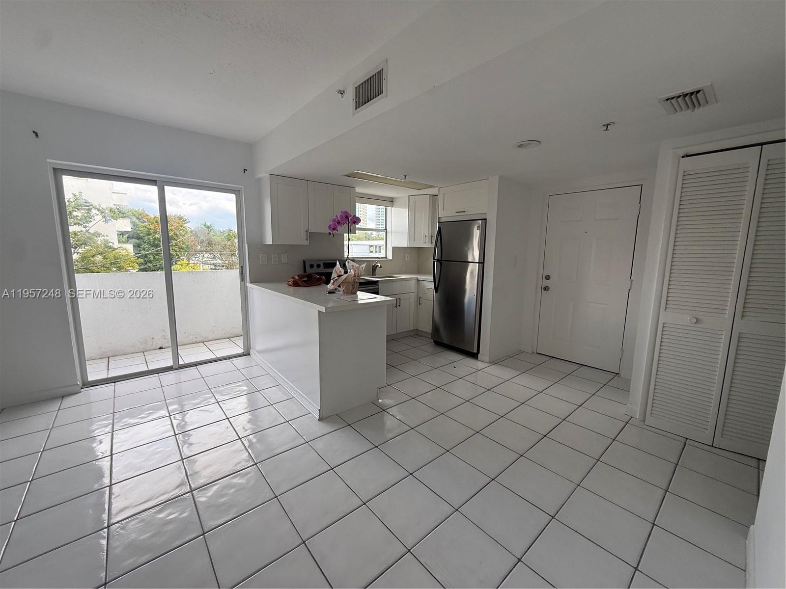 3052 Southwest 27th Avenue, Unit 301 Miami, FL 33133 - Photo 2 of 16 a kitchen with stainless steel appliances a refrigerator and sink