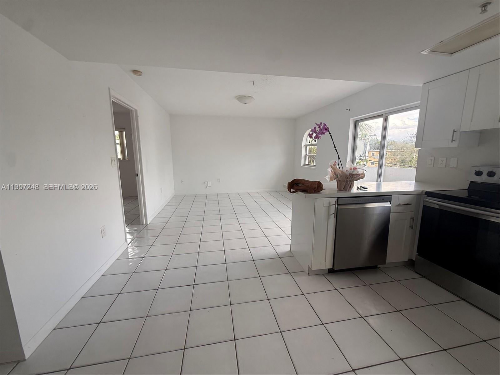 3052 Southwest 27th Avenue, Unit 301 Miami, FL 33133 - Photo 3 of 16 a utility room with cabinets dryer and washer