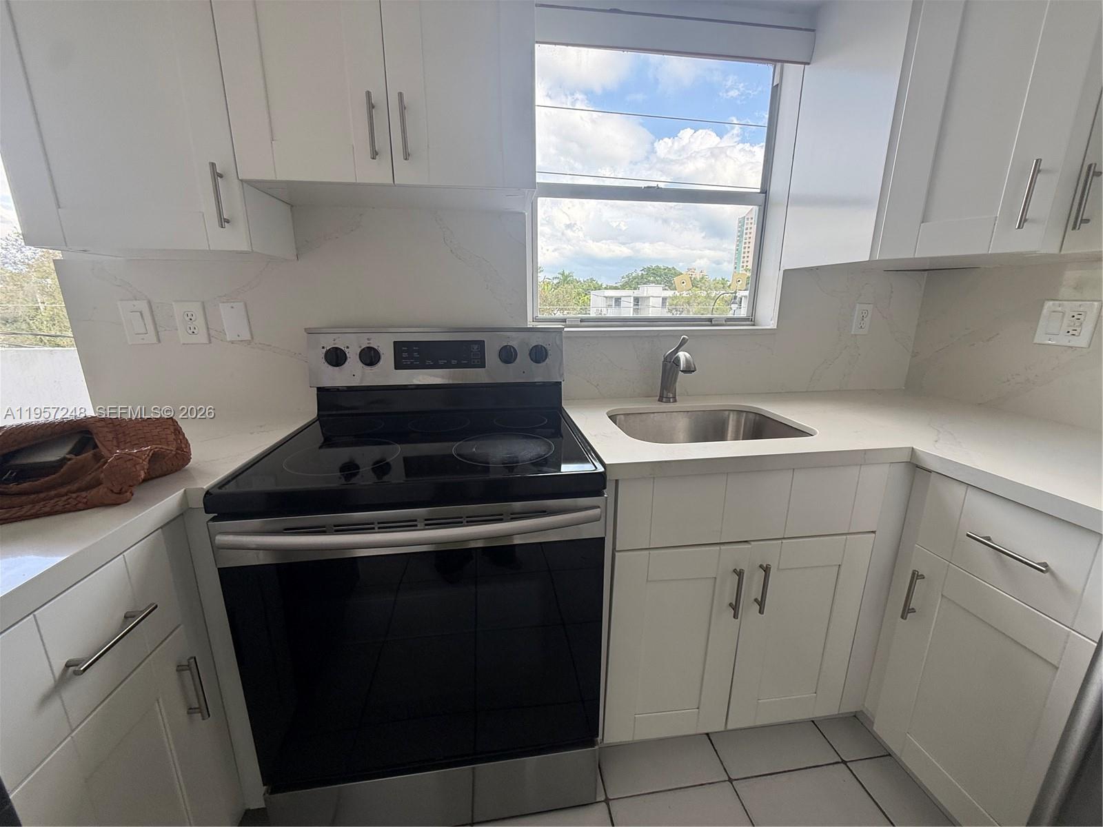 3052 Southwest 27th Avenue, Unit 301 Miami, FL 33133 - Photo 6 of 16 a kitchen with a sink stove and cabinets