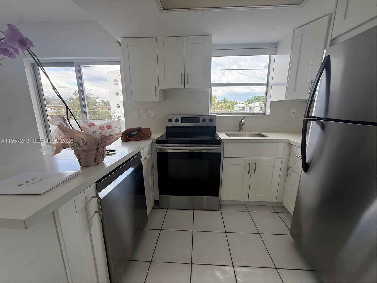 3052 Southwest 27th Avenue, Unit 301 Miami, FL 33133 - Photo 7 of 16 a kitchen with a stove sink and refrigerator