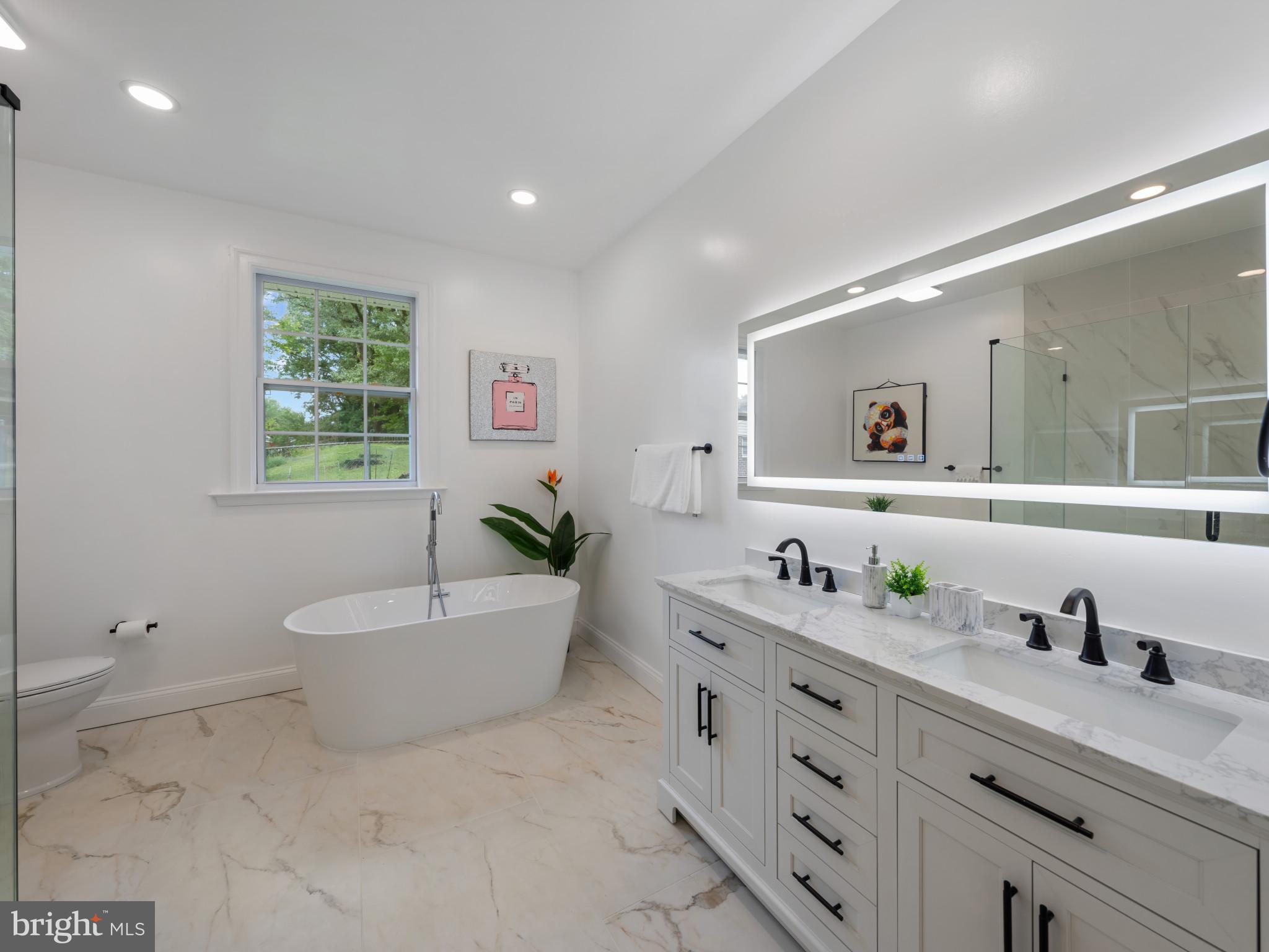 5503 Blacksburg Road Springfield, VA 22151 - Photo 22 of 30 a spacious bathroom with a granite countertop sink mirror and bathtub