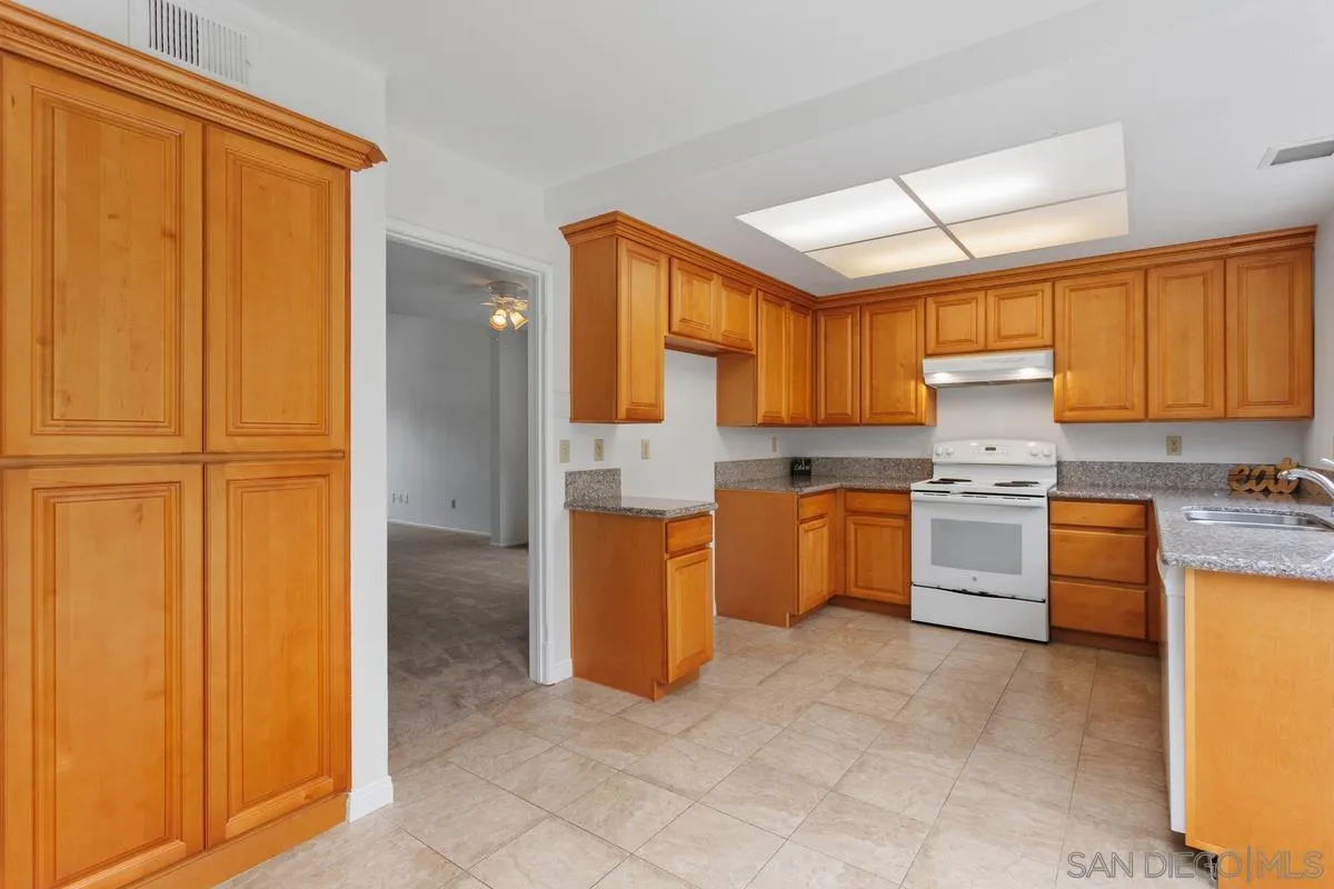 4617 Sheridan Road Oceanside, CA 92056 - Photo 13 of 39 a kitchen with granite countertop a sink cabinets stainless steel appliances and a window