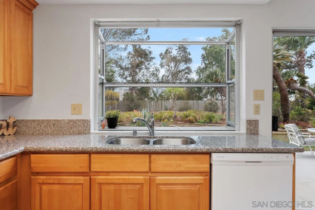 4617 Sheridan Road Oceanside, CA 92056 - Photo 15 of 39 a kitchen with granite countertop white cabinets and a window