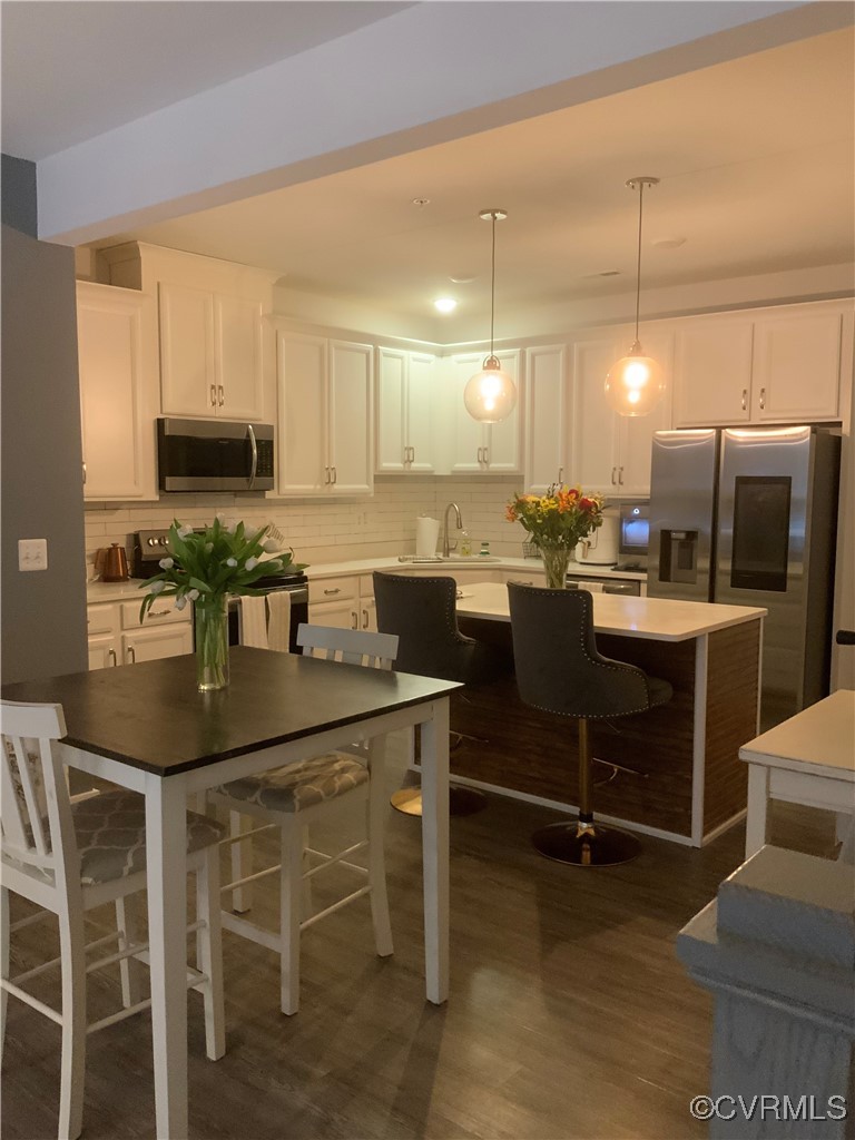 4324 Saunders Station Loop, Unit A Henrico, VA 23233 - Photo 11 of 30 a kitchen with kitchen island granite countertop a table chairs microwave and cabinets