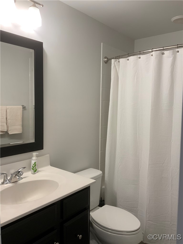 4324 Saunders Station Loop, Unit A Henrico, VA 23233 - Photo 24 of 30 a bathroom with a sink a toilet a mirror and shower curtain