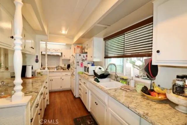 a large white kitchen with kitchen island a large window a sink and a counter space