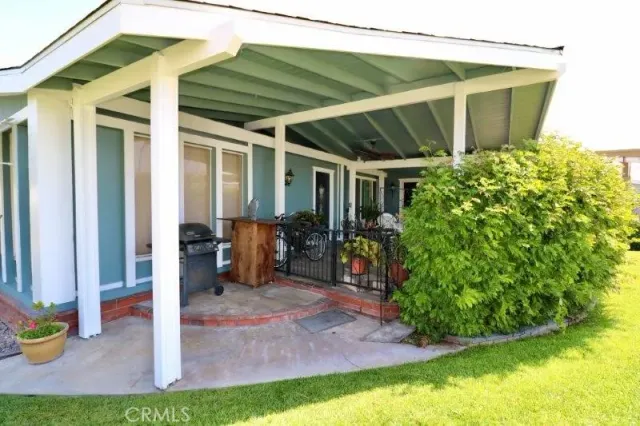 a view of a backyard with table and chairs under an umbrella