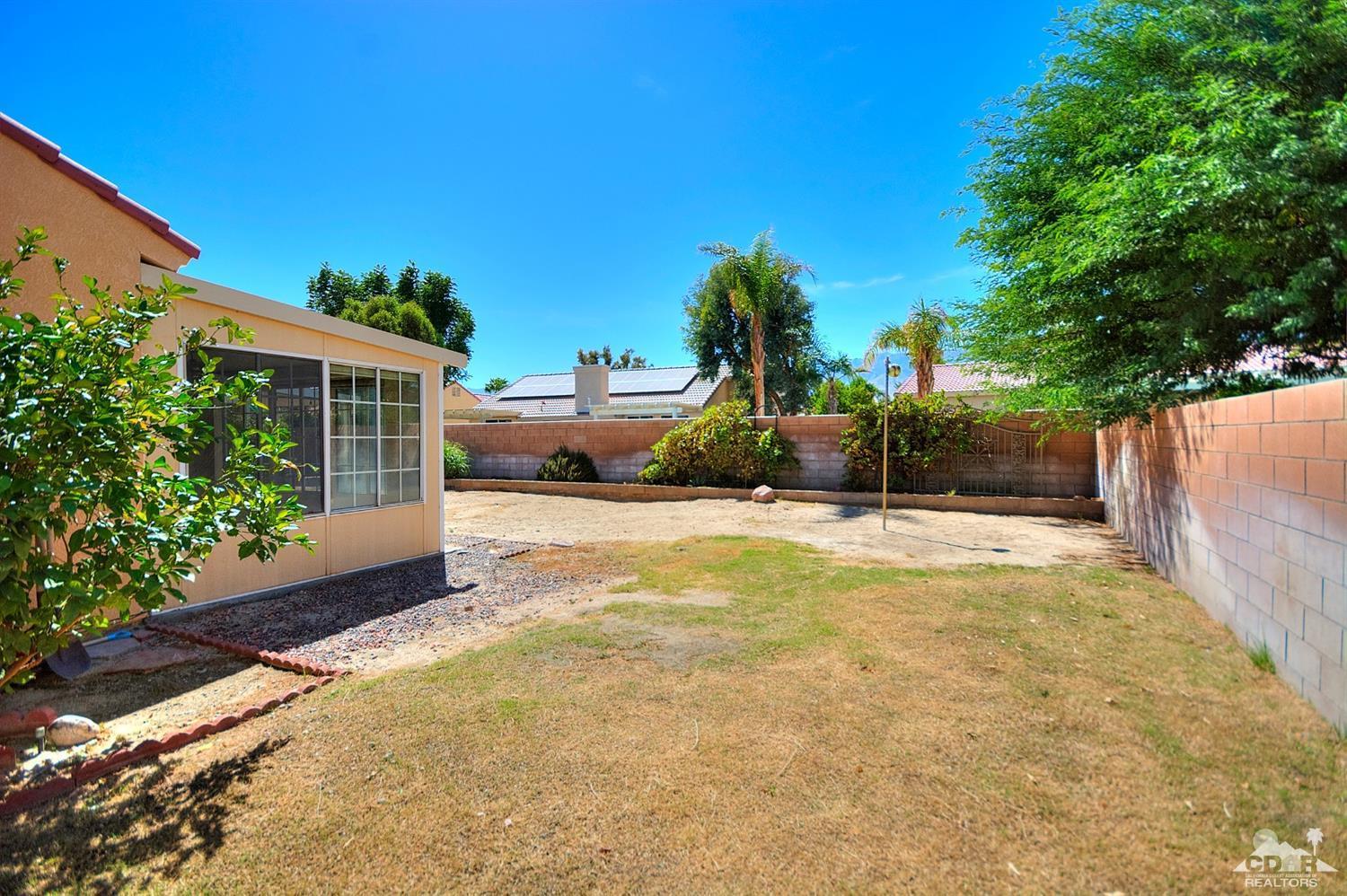 68237 Pasada Road Cathedral City, CA 92234 - Photo 30 of 30 a view of a backyard house with large tree and plants