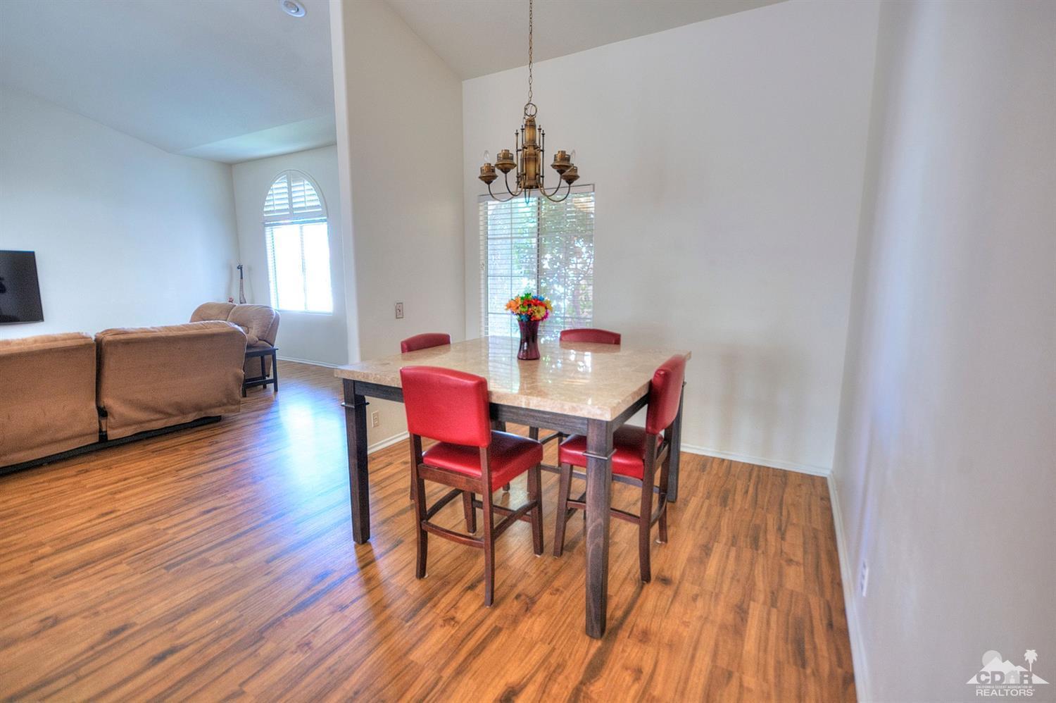 68237 Pasada Road Cathedral City, CA 92234 - Photo 7 of 30 a dining room with furniture wooden floor a rug and a chandelier