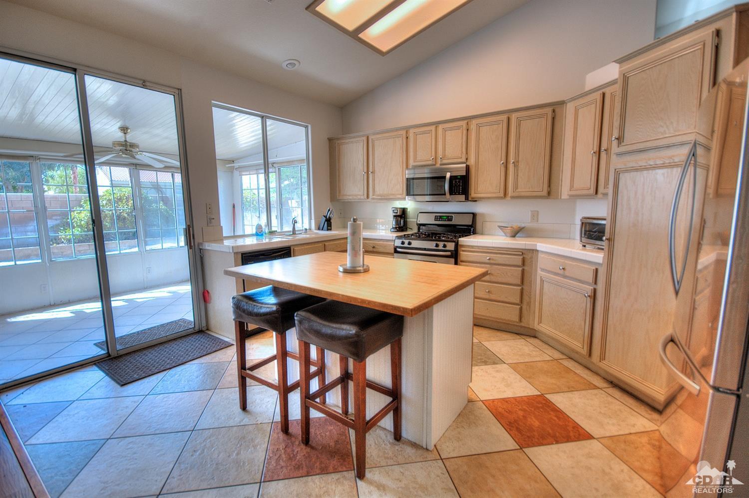 68237 Pasada Road Cathedral City, CA 92234 - Photo 10 of 30 a kitchen with stainless steel appliances a stove a sink refrigerator and a view of living room