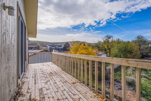 a view of a balcony with wooden floor and fence