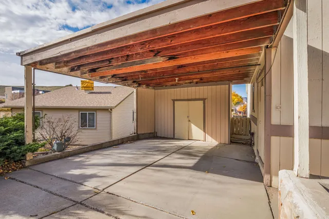 a view of backyard with plants and wooden fence