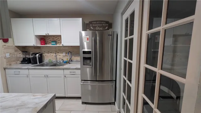 a kitchen with stainless steel appliances granite countertop a refrigerator and a sink