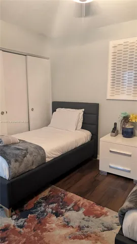 a bedroom with a bed window and a chandelier