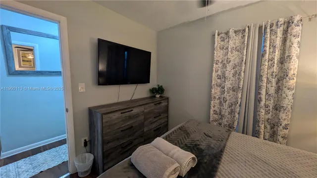 a bedroom with a bed and a flat screen tv