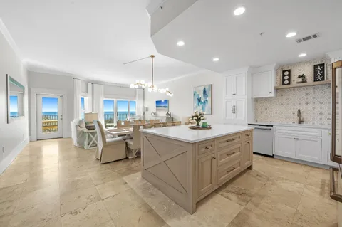 a large white kitchen with a lot of counter space and a refrigerator