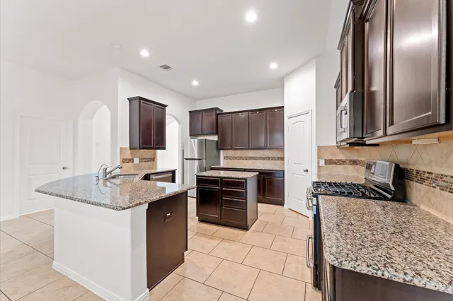 a kitchen with stainless steel appliances granite countertop a stove oven and a sink
