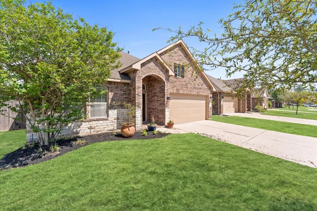 a front view of a house with a yard and trees