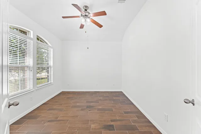 a view of a big room with wooden floor and windows in a room