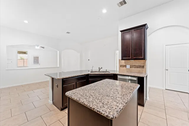 a kitchen with granite countertop cabinets and window