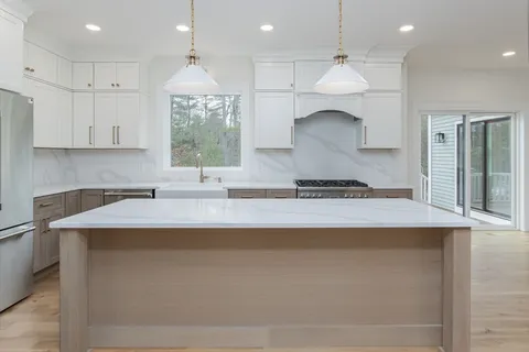 a large white kitchen with a large window
