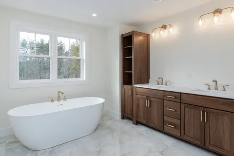 a bathroom with a tub sink and mirror