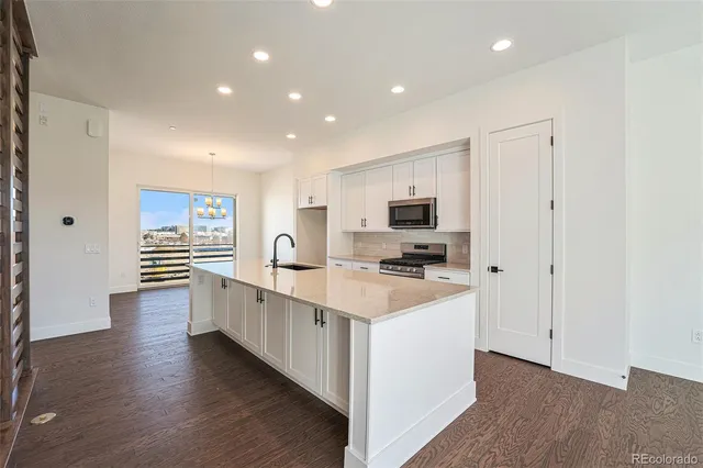 a view of a kitchen with refrigerator and wooden floor