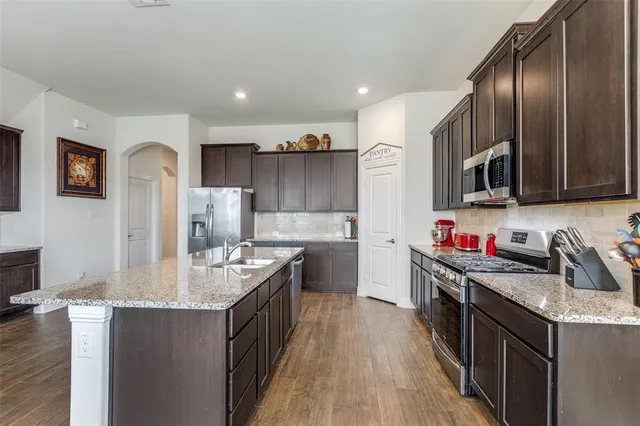 a kitchen with stainless steel appliances a refrigerator sink and microwave
