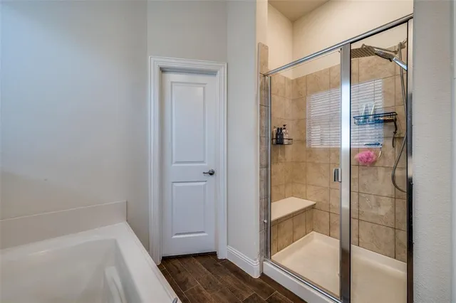 a bathroom with bathtub and wooden floor