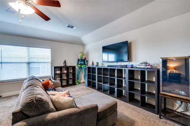 a living room with furniture a ceiling fan and a rug