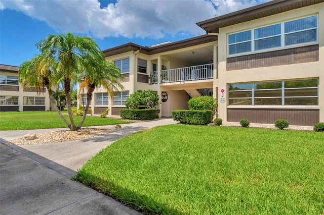 a front view of a house with a yard and palm tree