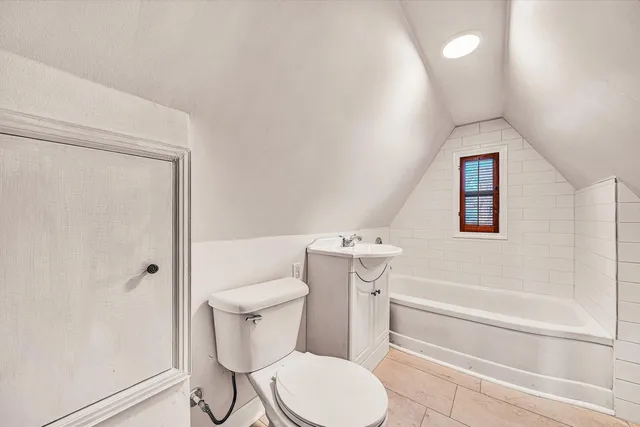 a white toilet sitting next to a bath tub