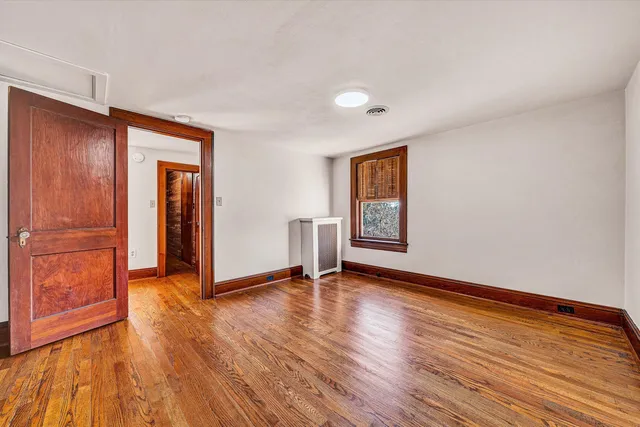 an empty room with wooden floor and closet