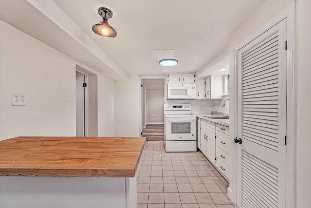 a kitchen with granite countertop a stove cabinets and a refrigerator
