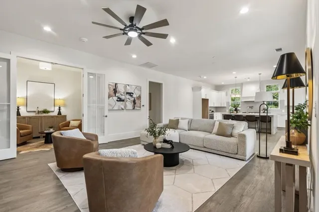 a living room with furniture kitchen view and a chandelier