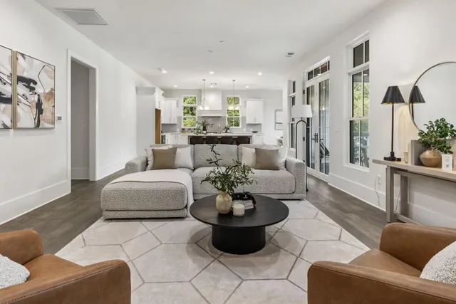 a living room with furniture potted plant and kitchen view