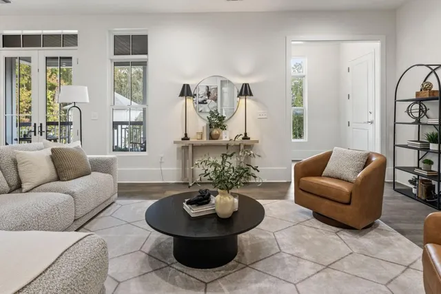 a living room with furniture a chandelier and a large mirror
