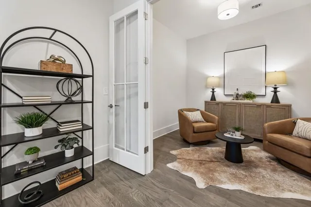 a living room with furniture a flat screen tv and a window