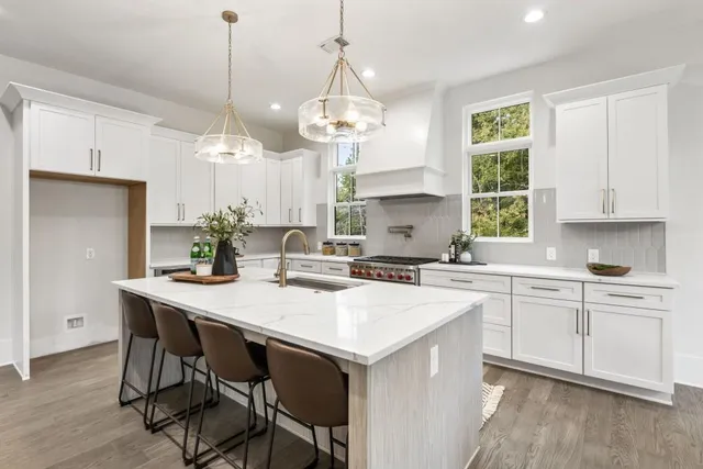 a kitchen with a table a sink cabinets and wooden floor